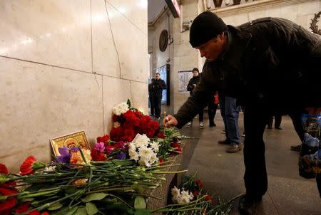 A man leaves a candle in memory of victims of a blast in St.Petersburg metro, at Tekhnologicheskiy institut metro station in St. Petersburg, Russia, April 4, 2017. REUTERS/Grigory Dukor