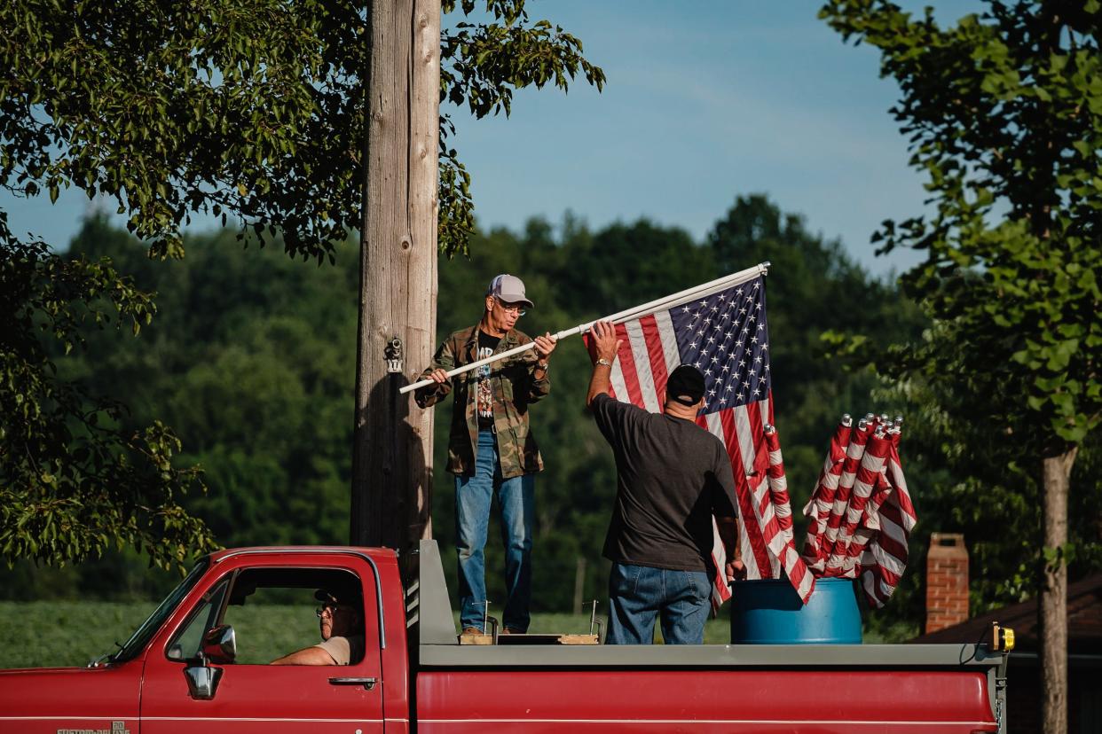 Flags are collected from along the road in Bolivar by members of American Legion Post 190 in 2021.