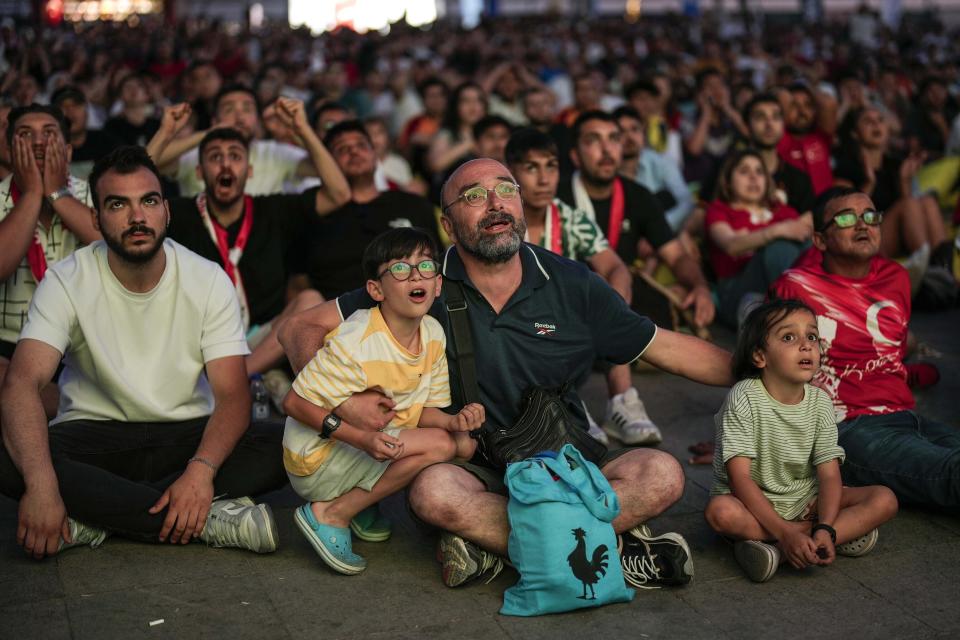 Turkish supporters watch the Group F match between Turkey and Georgia at the Euro 2024 soccer tournament being played in Dortmund, Germany, Tuesday, June 18, 2024 in Kadikoy district in Istanbul. (AP Photo/Francisco Seco)