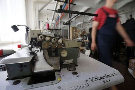 An employee of clothing retailer Arena Modna Kuca walks past machinery at the company's factory in the Adriatic town of Pula July 1, 2014. REUTERS/Antonio Bronic