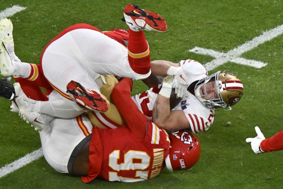 San Francisco 49ers running back Christian McCaffrey (23) is tackled by the Kansas City Chiefs during the first half of the NFL Super Bowl 58 football game Sunday, Feb. 11, 2024, in Las Vegas. (AP Photo/David Becker)