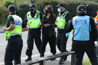 One protester is lead away by police outside the Newsprinters printing works at Broxbourne, Hertfordshire, other protesters use bamboo lock-ons and a van to continue to block the road. (Photo by Yui Mok/PA Images via Getty Images)