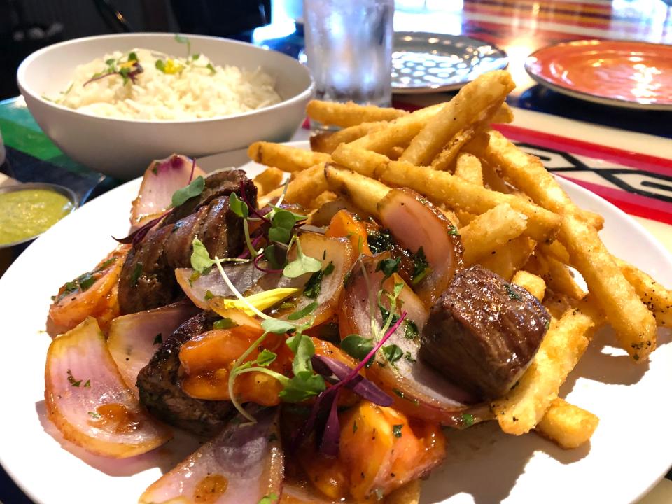 The Lomo Saltado at Triciclo Peru is a traditional Peruvian stir-fry dish of marinated steak, onions and tomato served with a side of french fries and rice.
