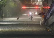 Mumbai: People wade through a waterlogged street after heavy monsoon rain, at Sion in Mumbai, Wednesday, Sept. 23, 2020. (PTI Photo/Kunal Patil)(PTI23-09-2020_000083A)