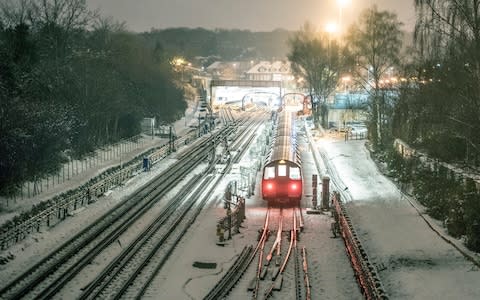 A Tube train in snowy conditions early on Monday - Credit: JEREMY SELWYN /eyevine