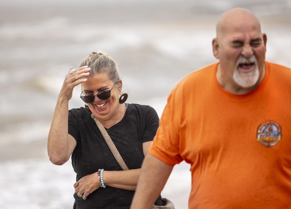 Doris and Warren Todd walk away from pelting rain as Tropical Storm Ophelia passes over Colonial Beach in Westmoreland County, Va., on Saturday, Sept. 23, 2023. The couple had just celebrated their 34th wedding anniversary after marrying on Sept. 22, 1989, when hurricane Hugo made landfall in North Carolina. (Peter Cihelka/The Free Lance-Star via AP)