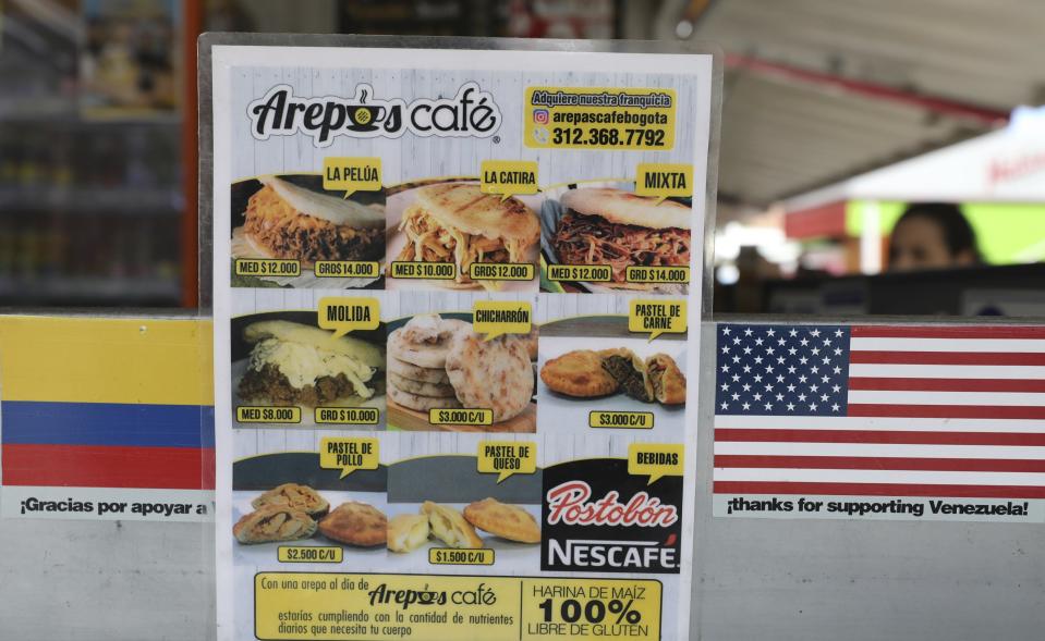 This June 11, 2019 photo, shows the menu at the "Arepas Cafe" restaurant in Bogota, Colombia, Tuesday, June 11, 2019. Owner Gerson Briceño noted he takes pride in seeing Colombians become repeat customers and order classics like the reina pepiada with chicken salad and avocado. (AP Photo/Fernando Vergara)