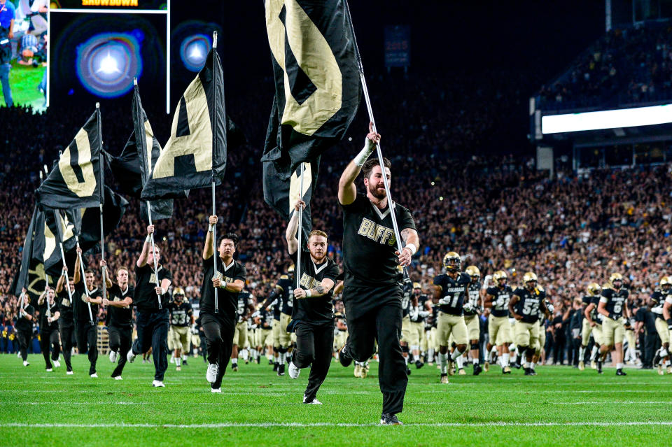 DENVER, CO - AUGUST 30:  Colorado Buffaloes cheerleaders run across the field with flags and the Colorado Buffaloes team before a game between the Colorado Buffaloes and the Colorado State Rams at Broncos Stadium at Mile High on August 30, 2019 in Denver, Colorado.  (Photo by Dustin Bradford/Getty Images)