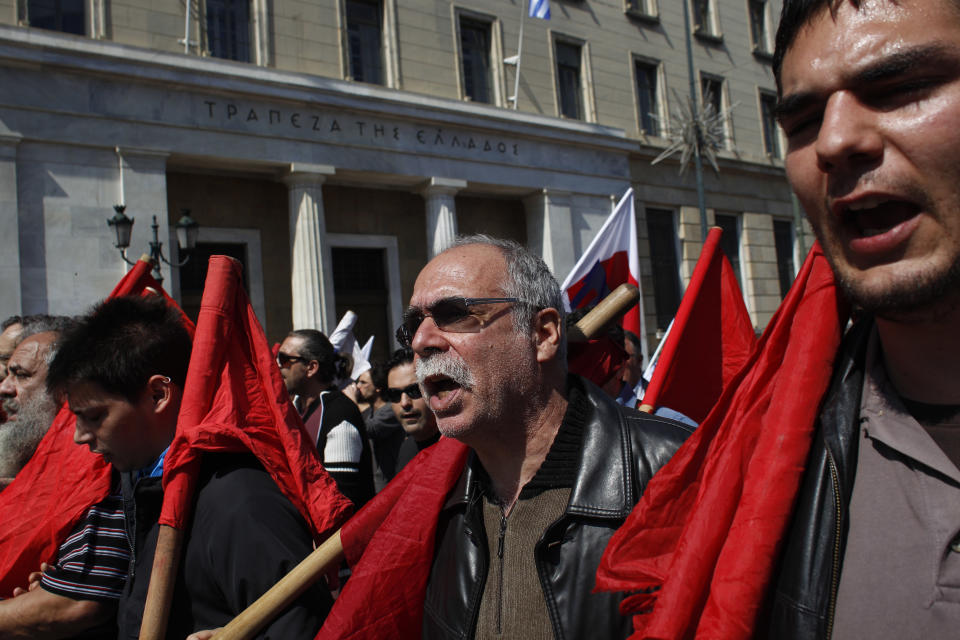 People chant slogans as they march in front of the Bank of Greece, during a protest in Athens on Wednesday April 9, 2014. Greek unions launched an anti-austerity general strike that halted train and island ferry services while disrupting state hospitals and other public services. Thousands of protesters marched through central Athens in the first of two planned demonstrations. (AP Photo/Kostas Tsironis)
