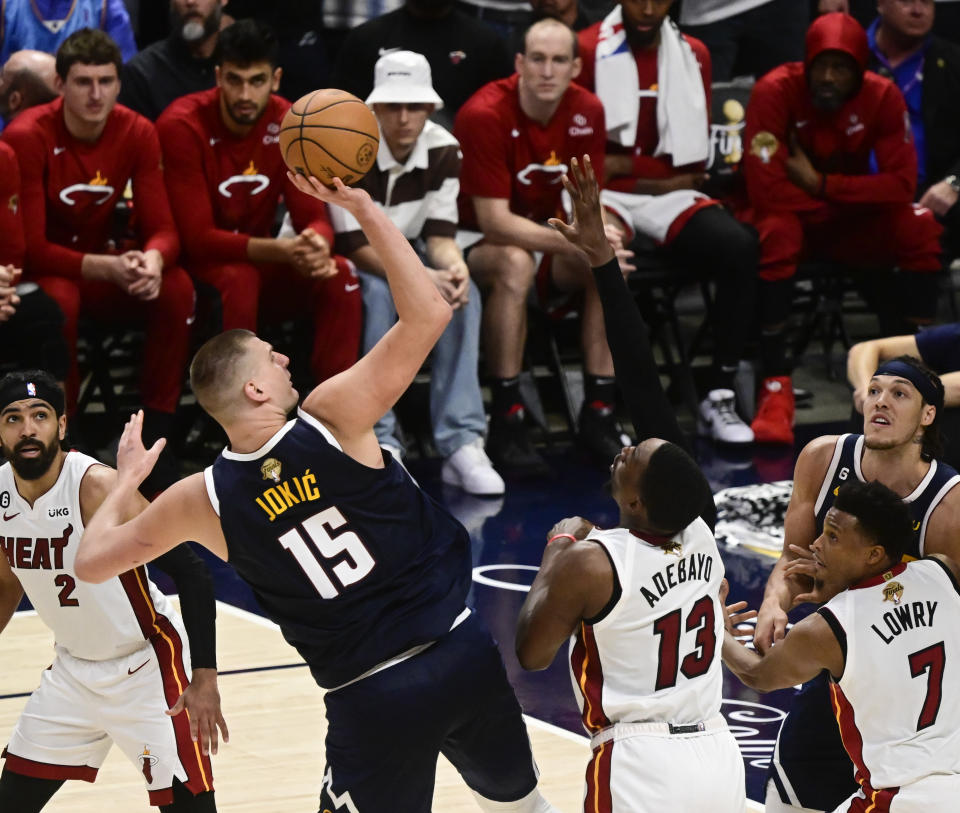 DENVER, CO - 4 JUNI: Nikola Jokic (15) dari Denver Nuggets mencoba melakukan tembakan melawan Bam Adebayo (13) dari Miami Heat dan Kyle Lowry (7) dari Miami Heat di kuarter keempat selama Game 2 Final NBA di Ball Arena 4 Juni 2023 (Foto oleh Andy Cross/Grup MediaNews/The Denver Post via Getty Images)