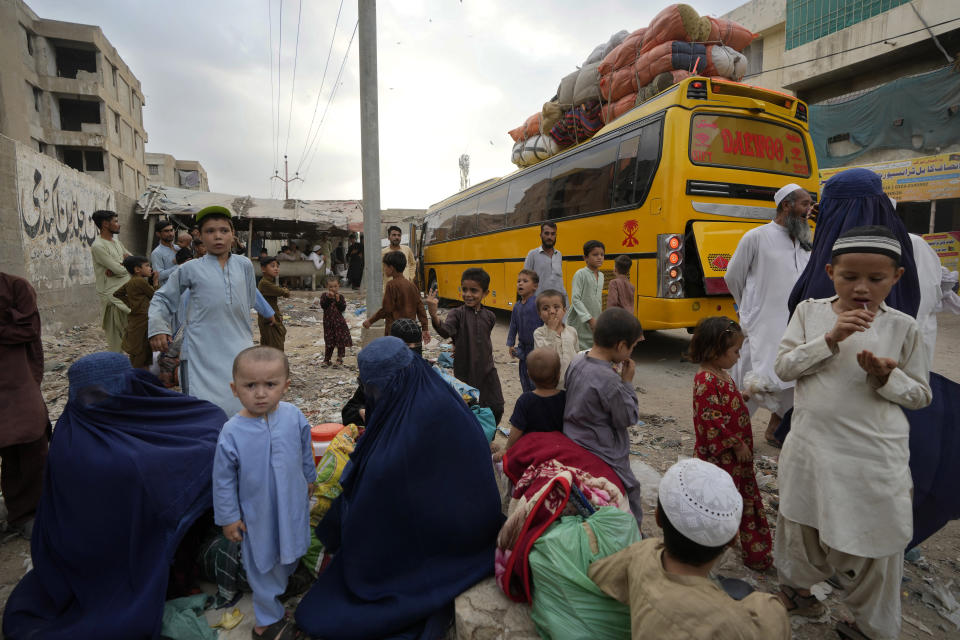 Afghan families wait to board into a bus to depart for their homeland, in Karachi, Pakistan, Friday, Oct. 6, 2023. Pakistan's government announced a major crackdown Tuesday on migrants in the country illegally, saying it would expel them starting next month and raising alarm among foreigners without documentation who include an estimated 1.7 million Afghans. (AP Photo/Fareed Khan)