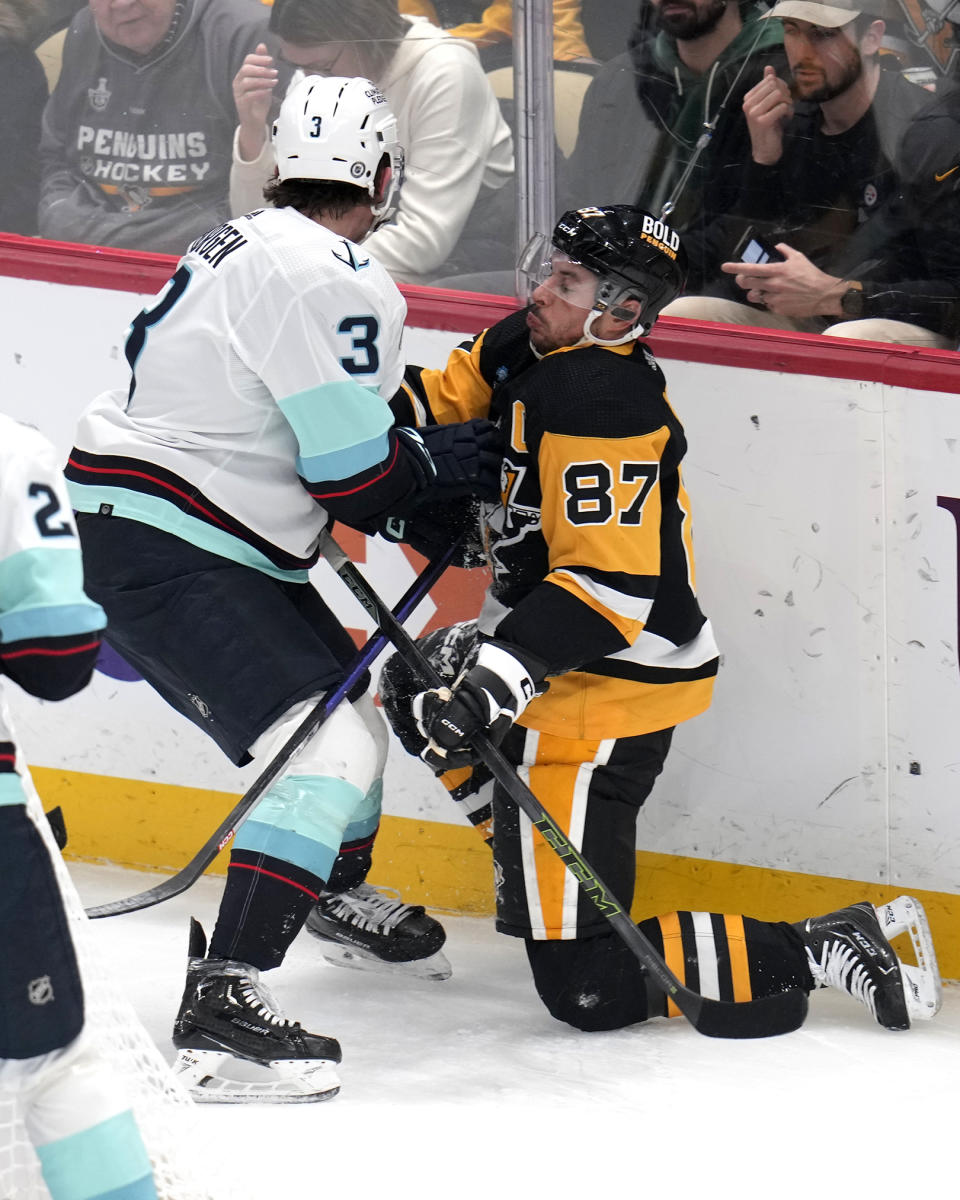 Pittsburgh Penguins' Sidney Crosby (87) is defended by Seattle Kraken's Will Borgen during the first period of an NHL hockey game in Pittsburgh, Monday, Jan. 15, 2024. (AP Photo/Gene J. Puskar)