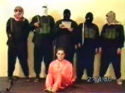 A frame grab taken from website video footage May 11, 2004, shows a man, who identified himself as Nick Berg of Philadelphia (C) seated in front of his five masked captors moments before he was executed. Al Qaeda's leader in Iraq beheaded an American civilian and vowed more killings in revenge for the abuse of Iraqi prisoners, an Islamist Web site said on Tuesday. After one of the masked men read out a statement, they pushed Berg to the floor and shouted "God is greatest" above his screams as one of them sawed his head off with a large knife then held it aloft for the camera. It was not immediately possible to verify the authenticity of the tape carried on the Muntada al-Ansar Islamist Web site. REUTERS/Reuters TV AA/HB