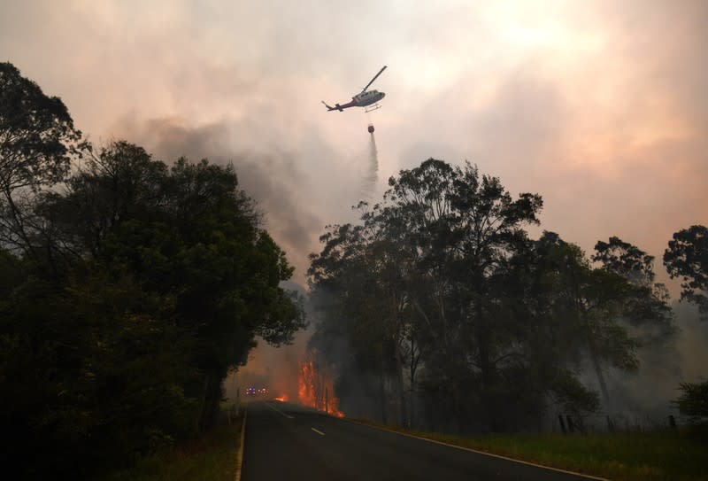 A water bomber drops its load on a bushfire in Nana Glen