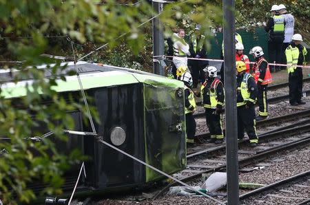 Members of the emergency services work next to a tram after it overturned injuring and trapping some passengers in Croydon, south London, Britain November 9, 2016. REUTERS/Neil Hall