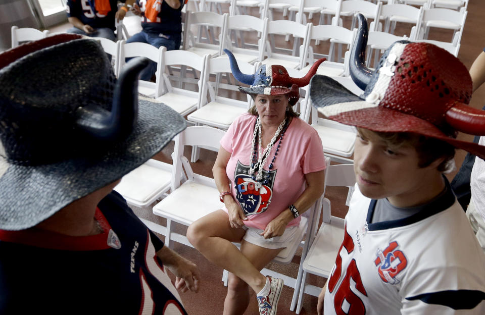 Houston Texans fans Beth Morgan, center, her son Daniel, right, and husband Donny, left, wait for the start of the NFL draft as they attend a Houston Texans draft day party at NRG Stadium Thursday, May 8, 2014, in Houston. The Texans have the first pick in the NFL draft. (AP Photo/David J. Phillip)