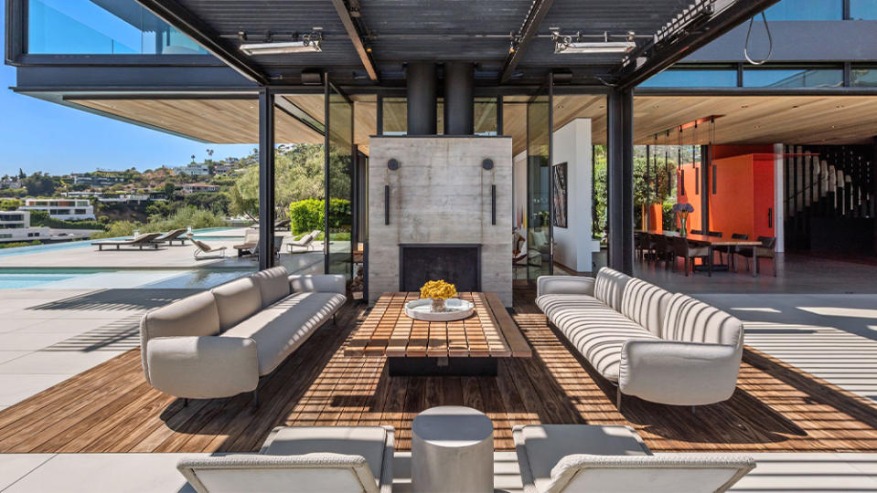 An al fresco living room with elegant fire pit and hillside views.