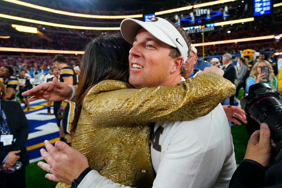 Missouri coach Eliah Drinkwitz, right, celebrates with athletic director Desiree Reed-Francois after Missouri defeated Ohio State in the Cotton Bowl NCAA college football game Friday, Dec. 29, 2023, in Arlington, Texas. (AP Photo/Julio Cortez)