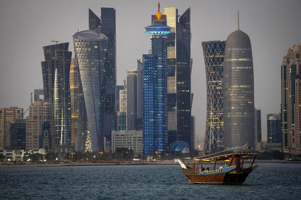 FILE - A traditional dhow boat sails towards the West Bay in Doha, Qatar, Thursday, Nov. 25, 2021. Qatar has sought to portray itself as welcoming foreigners to this hereditarily ruled emirate, where traditional Muslim values remain strong.(AP Photo/Darko Bandic, File)