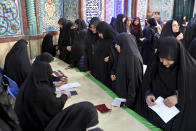 Voters register to cast their vote during the parliament elections at a polling station in Tehran, Iran, Friday, Feb. 21, 2020. Iranians began voting for a new parliament Friday, with turnout seen as a key measure of support for Iran's leadership as sanctions weigh on the economy and isolate the country diplomatically. (AP Photo/Ebrahim Noroozi)