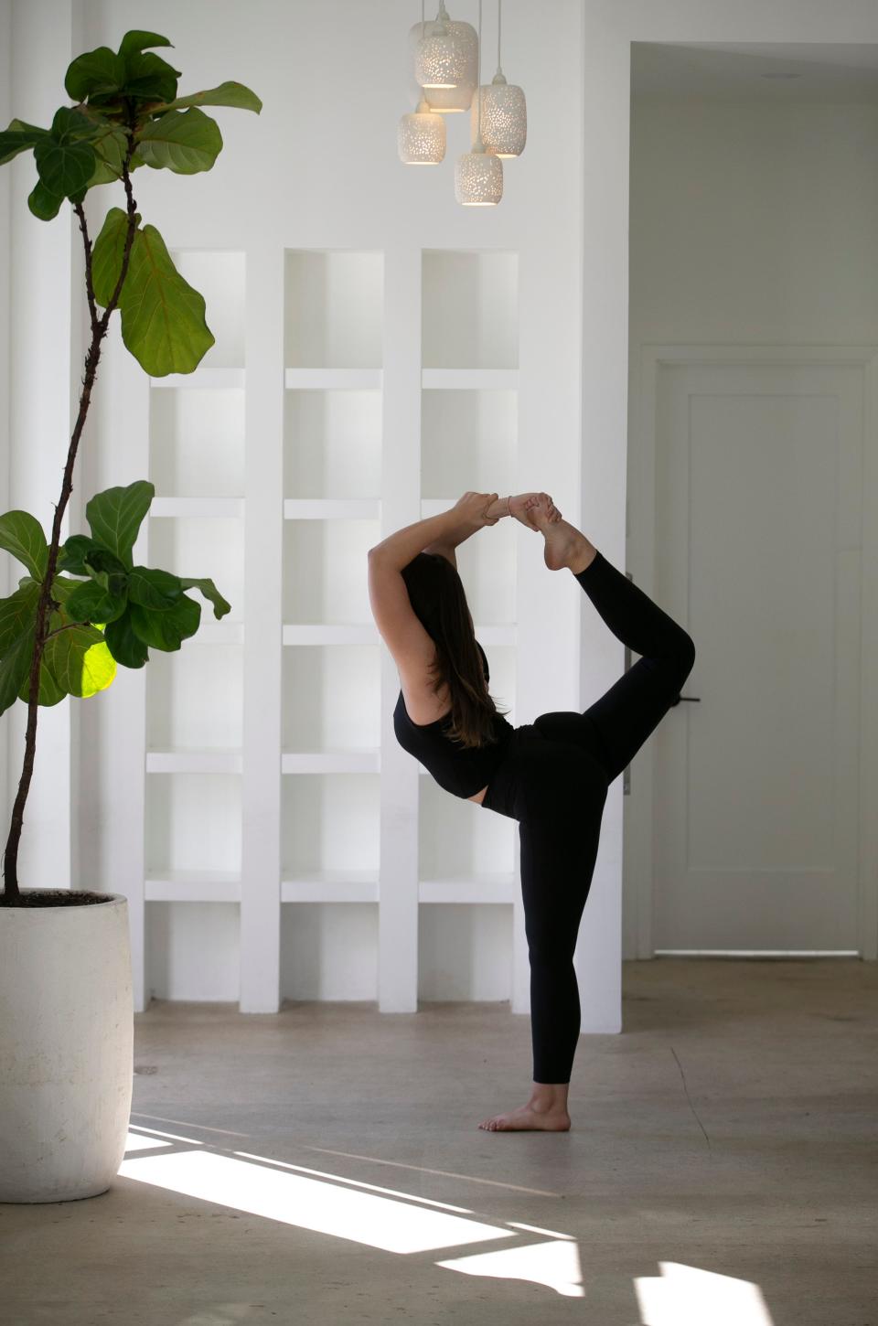 Owner Natalia DiFolco demonstrates various yoga positions in the spacious studio. Bask Hot Yoga is a Brielle-based business that provides yoga sessions in a relaxed, open atmosphere.  Manasquan, NJWednesday, November 2, 2022