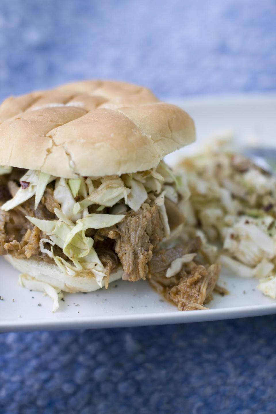 This July 15, 2013 photo shows a North Carolina-style pulled pork sandwich with North Carolina barbecue sauce and coleslaw. (AP Photo/Matthew Mead)