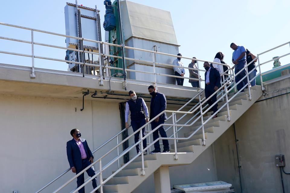 FILE - EPA Administrator Michael Regan, third from left, and Jackson Mayor Chokwe Antar Lumumba, climb down from a section of the Jackson Water Treatment Facility in Ridgeland, Miss., on Nov. 15, 2021. The Environmental Protection Agency is taking a series of enforcement actions to address air pollution, unsafe drinking water and other problems in minority communities in three Gulf Coast states that Administrator Michael Regan visited as part of a "Journey to Justice" tour last fall. (AP Photo/Rogelio V. Solis, File)