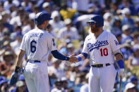 Los Angeles Dodgers' Trea Turner, left, and Justin Turner shake hands after Trea Turner scored on a single hit by Will Smith during the second inning of a baseball game against the St. Louis Cardinals Sunday, Sept. 25, 2022, in Los Angeles. (AP Photo/Jae C. Hong)