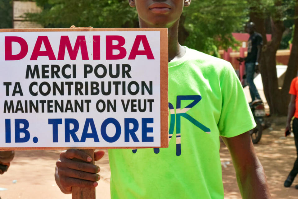 A protestor holds banner written “Damiba thank your for your contribution, now we want I B Traore” during a demonstration after a claimed coup in Ouagadougou on October 2, 2022. – Security forces fired tear gas to disperse angry protesters outside the French embassy in Burkina Faso’s capital on Sunday, as unrest simmered in the impoverished, restive West African nation following the claim of a second coup this year. Burkina Faso’s junta leader agreed to step down on October 2, 2022, two days after military officers announced he had been removed from power, religious and community leaders said. (Photo by AFP) (Photo by -/AFP via Getty Images)
