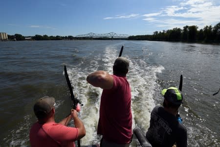 Steve Tubergen, 40, a residential buiilder from Hamilton, Michigan, fires into the water while out with the Peoria Carp Hunters on the Illinois River, hunting Asian carp