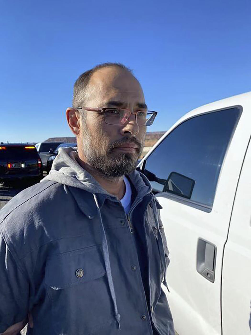 This photo posted on the Custer County Sheriff's Office Facebook page shows Hanme K. Clark as he's taken into custody by personnel from the New Mexico State Police and the U.S. Marshals Service, near Albuquerque, N.M., Tuesday, Nov. 21, 2023. Clark was captured after 25 hours on the run after police say he fatally shot three people and critically wounded a fourth in his latest property dispute with neighbors in rural Colorado, authorities said. (Courtesy of Custer County Sheriff's Office via AP)