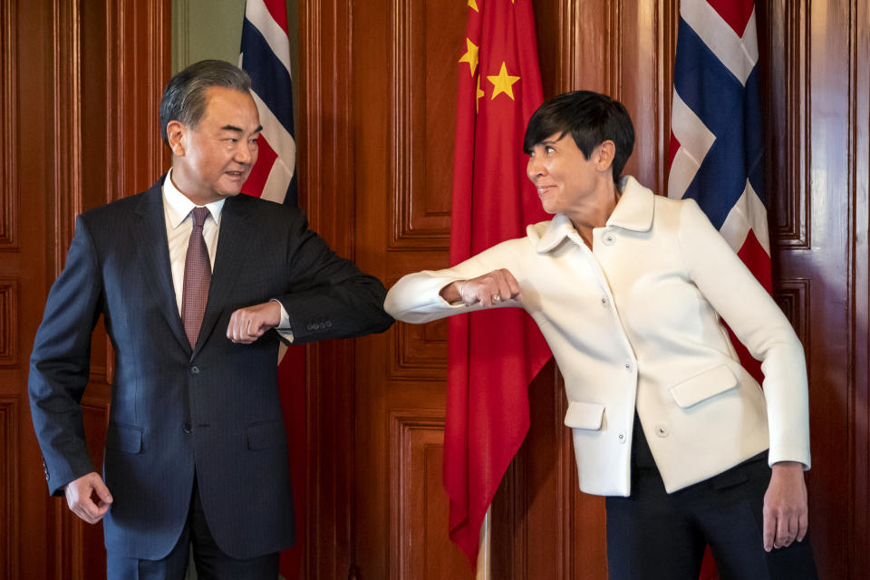 Chinese Foreign Minister Wang Yi, left, does a socially distanced greeting with Norwegian Foreign Minister Ine Eriksen Soreide during a short visit to Oslo, Thursday, Aug. 27, 2020. The visit is part of a round trip to several European countries. (Heiko Junge/NTB scanpix via AP)