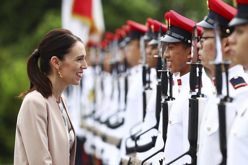 New Zealand's Prime Minister Jacinda Ardern speaks with a member of the honor guard during a welcome ceremony at the Istana or presidential palace in Singapore, Friday, May 17, 2019. (AP Photo/Yong Teck Lim)