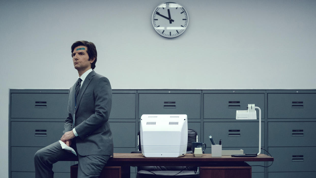  Mark S sits on the edge of a Lumon desk with a plaster on his head in Severance season 1, which arrived before Severance season 2. 