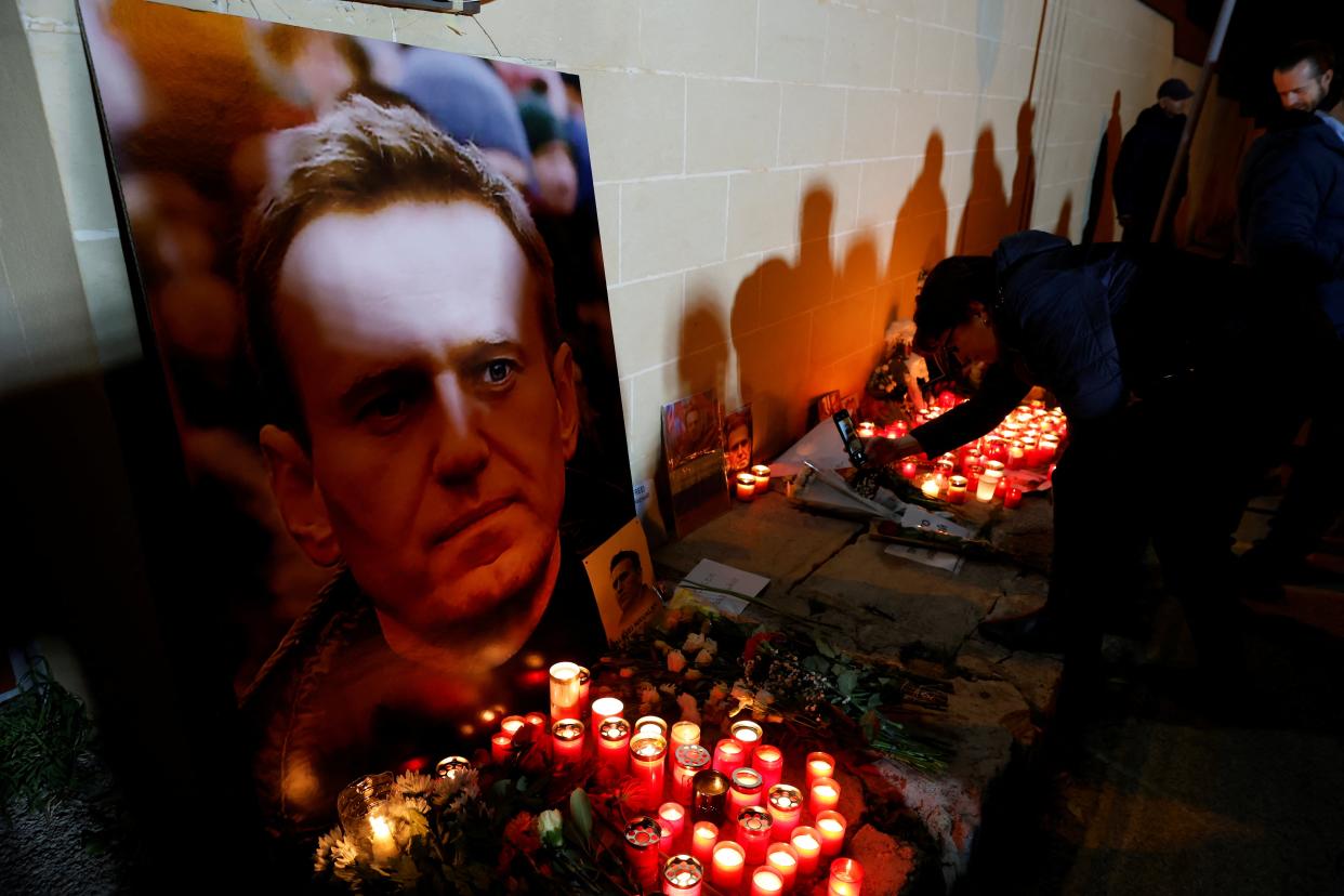 A woman takes pictures of a makeshift memorial for Russian opposition leader Alexei Navalny (Reuters)