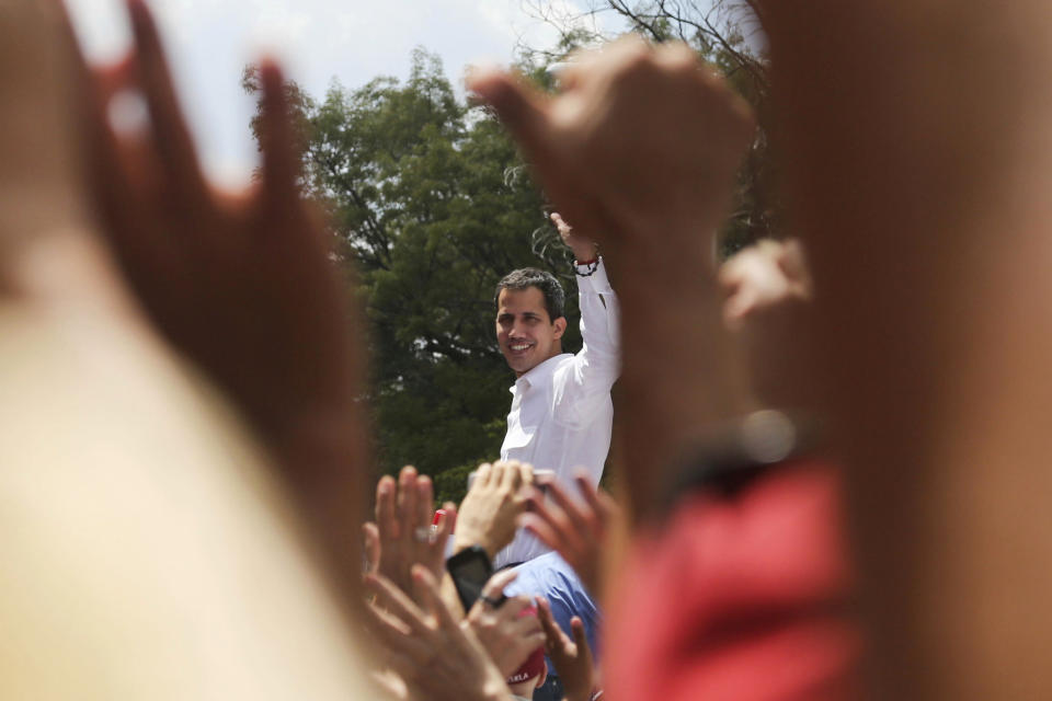 The leader of Venezuela's National Assembly Juan Guaido who declared himself the country's interim president, greets supporter upon his arrival to a rally against the government of President Nicolas Maduro in Caracas, Venezuela, Saturday, March 9, 2019. (AP Photo/Fernando Llano)