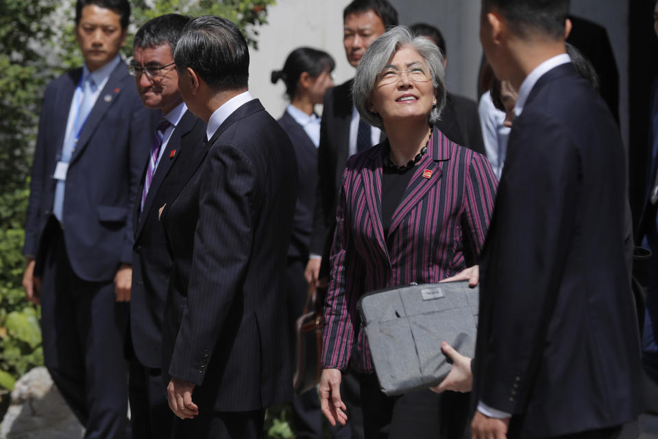 Chinese Foreign Minister Wang Yi, third from left, walks with his Japanese counterpart Taro Kono, second from left, and South Korean counterpart Kang Kyung-wha, second from right, for a joint press conference after their trilateral meeting at Gubei Town in Beijing Wednesday, Aug. 21, 2019. (Wu Hong/Pool Photo via AP)