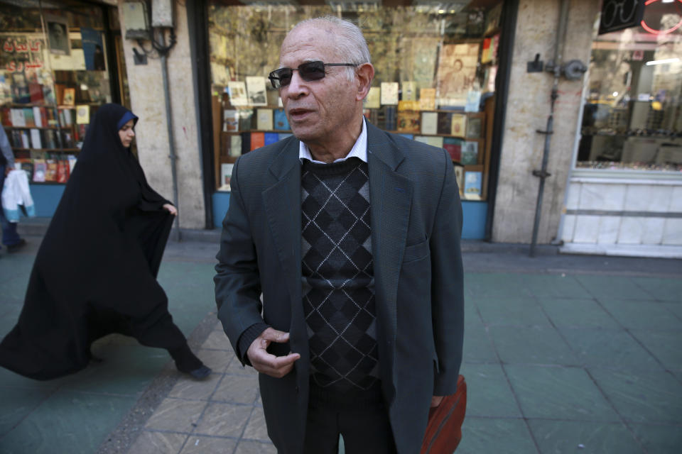 In this Jan. 23, 2019 photo, retired university professor, Ali Soltani, speaks to The Associated Press about Iran's 1979 Islamic Revolution, while walking along Enghelab, or Revolution Street, in downtown Tehran, Iran. Soltani, who has written books on Persian literature and Islamic teachings, called poverty the biggest challenge the country faces today. While life under the shah had at least three social classes -- the rich, the middle class and the poor -- Iran today is simply separated between the haves and the have-nots, he said. (AP Photo/Vahid Salemi)