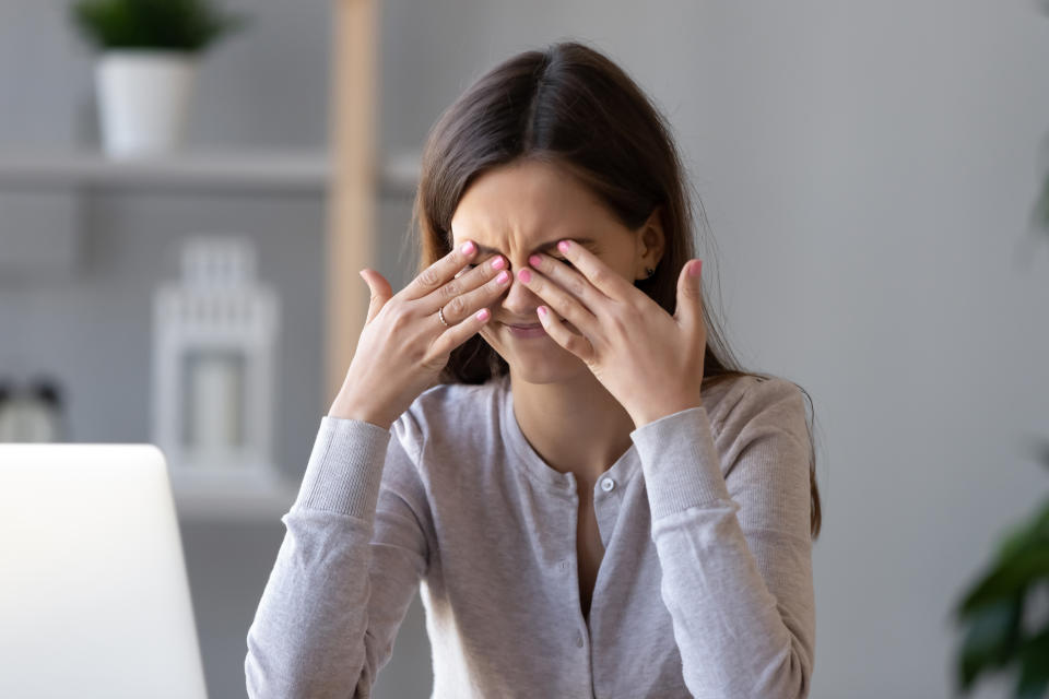 Tired teen girl rubbing dry irritable eyes feel eye strain tension migraine after computer work, exhausted young woman worker student relieving headache pain, bad weak blurry vision, eyesight problem