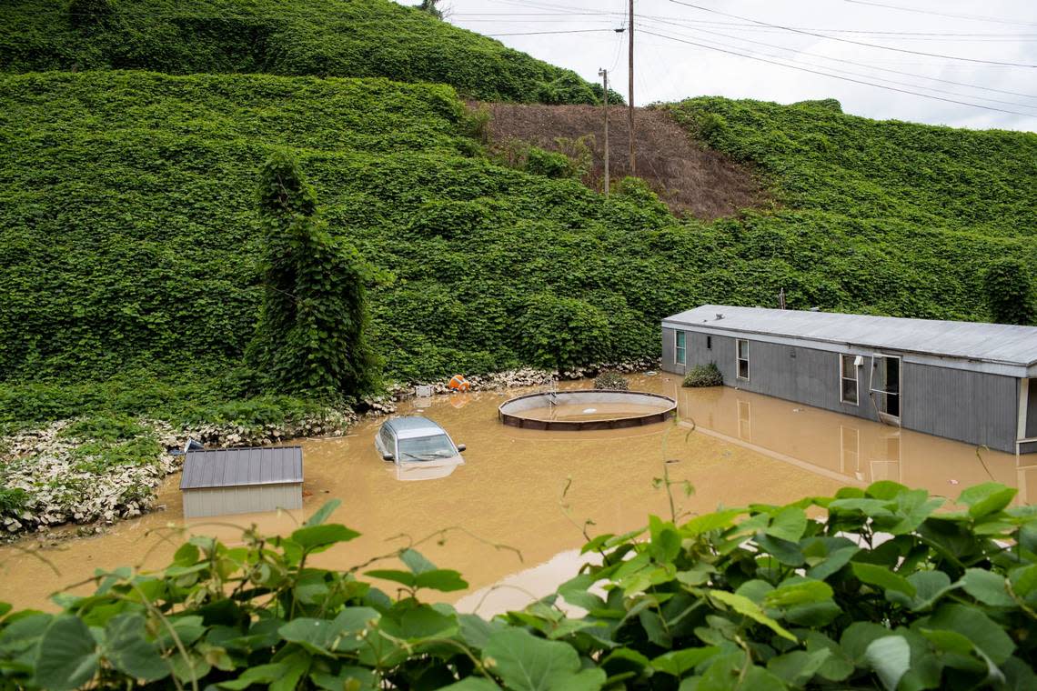 Vehicles and a home are still buried under floodwaters in Jackson, Ky., Friday, July 29, 2022.