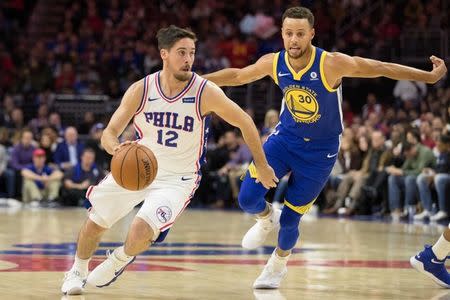 Nov 18, 2017; Philadelphia, PA, USA; Philadelphia 76ers guard T.J. McConnell (12) dribbles past Golden State Warriors guard Stephen Curry (30) during the first quarter at Wells Fargo Center. Mandatory Credit: Bill Streicher-USA TODAY Sports