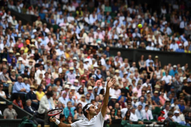 En esta foto de archivo tomada el 8 de julio de 2016, Roger Federer de Suiza sirve a Milos Raonic de Canadá durante el partido de semifinales masculino en el duodécimo día del Campeonato de Wimbledon 2016 en el All England Lawn Tennis Club en Wimbledon, suroeste de Londres.