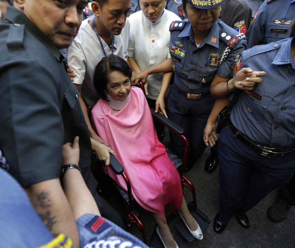 Former Philippine President Gloria Macapagal Arroyo, center, who is currently under hospital arrest, is wheeled into the courtroom of the Sandiganbayan (Anti-graft Court) upon arrival for her arraignment Monday, Oct. 29, 2012 at suburban Quezon city, northeast of Manila, Philippines. Arroyo, who is charged with plunder for allegedly misusing state lottery funds, refused to enter a plea and the anti-graft court entered a not guilty plea on her behalf. (AP Photo/Bullit Marquez)