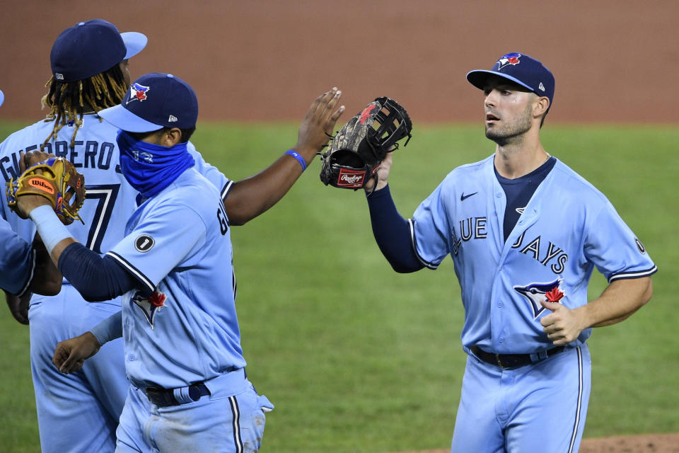 Toronto Blue Jays' Randal Grichuk, right, celebrates with Vladimir Guerrero Jr., back left, and Lourdes Gurriel Jr., front left, after a baseball game against the Baltimore Orioles, Monday, Aug. 17, 2020, in Baltimore. (AP Photo/Nick Wass)