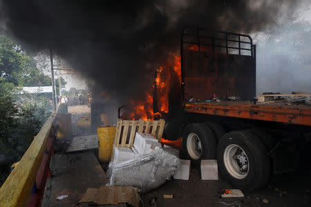 A truck that was carrying humanitarian aid for Venezuela is seen on fire after clashes between opposition supporters and Venezuela's security forces at Francisco de Paula Santander bridge on the border line between Colombia and Venezuela as seen from Cucuta, Colombia, February 23, 2019. REUTERS/Marco Bello