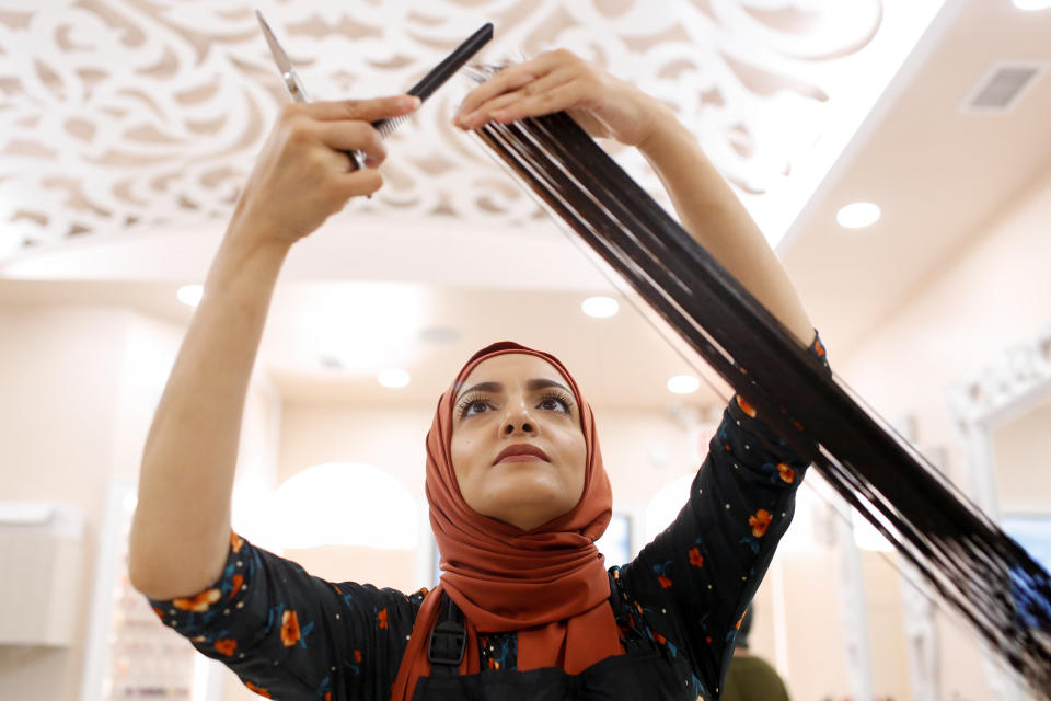 Huda Quhshi, owner and cosmetologist at the Le'Jemalik Salon and Boutique, cuts the hair of a Muslim woman ahead of the Eid al-Fitr Islamic holiday in Brooklyn, New York, U.S., June 21, 2017. Picture taken on June 21, 2017.&nbsp;