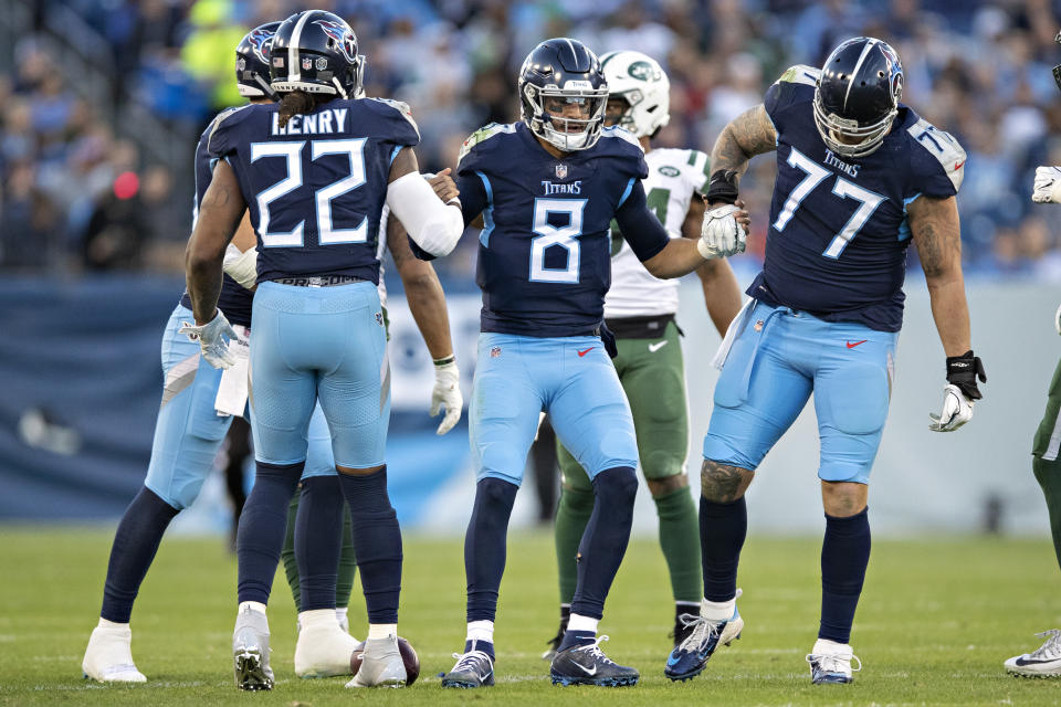 Marcus Mariota #8 is helped up by Taylor Lewan #77 and Derrick Henry #22 of the Tennessee Titans