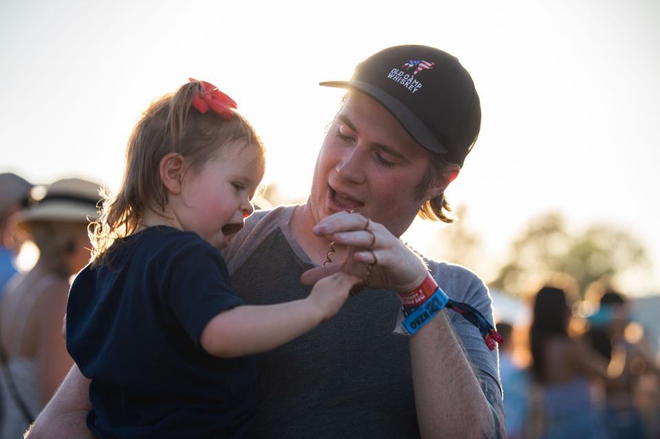 Garrett Walker plays with his baby, Lennox, during the second day of the Pilgrimage Music & Cultural Festival at the Park in Harlinsdale in Franklin, Tenn., Sunday, Sept. 26, 2021.