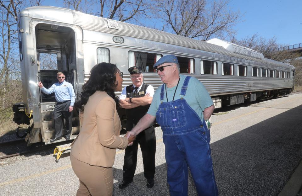 U.S. Rep. Emilia Sykes is greeted Monday by engineer Chad Winans, right, and conductor Tom Kovach at Akron's Northside Station as Cuyahoga Valley Scenic Railroad CEO Joe Mazur looks on.