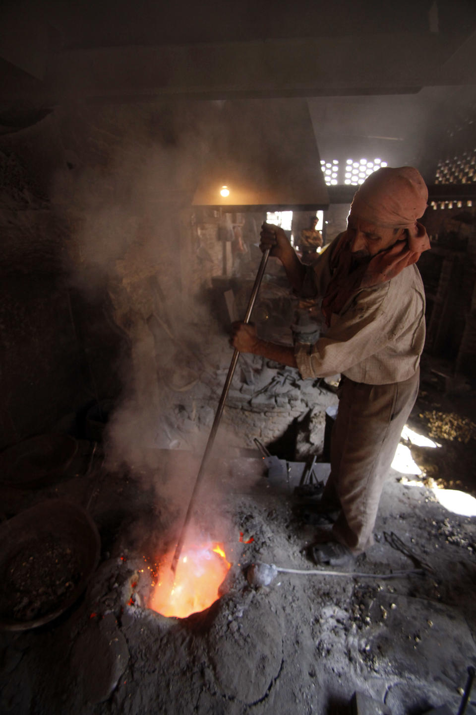 An Indian worker melts brass to make water taps at a factory on the outskirts of Jammu, India, Wednesday, Feb. 29, 2012. India's economy grew at its slowest pace in over two years in the December quarter, adding to pressure on the central bank to lower interest rates even as inflation remains high. The 6.1 percent growth reported Wednesday marks a sharp slowdown from a 6.9 percent expansion in the July-September quarter. (AP Photo/ Channi Anand)